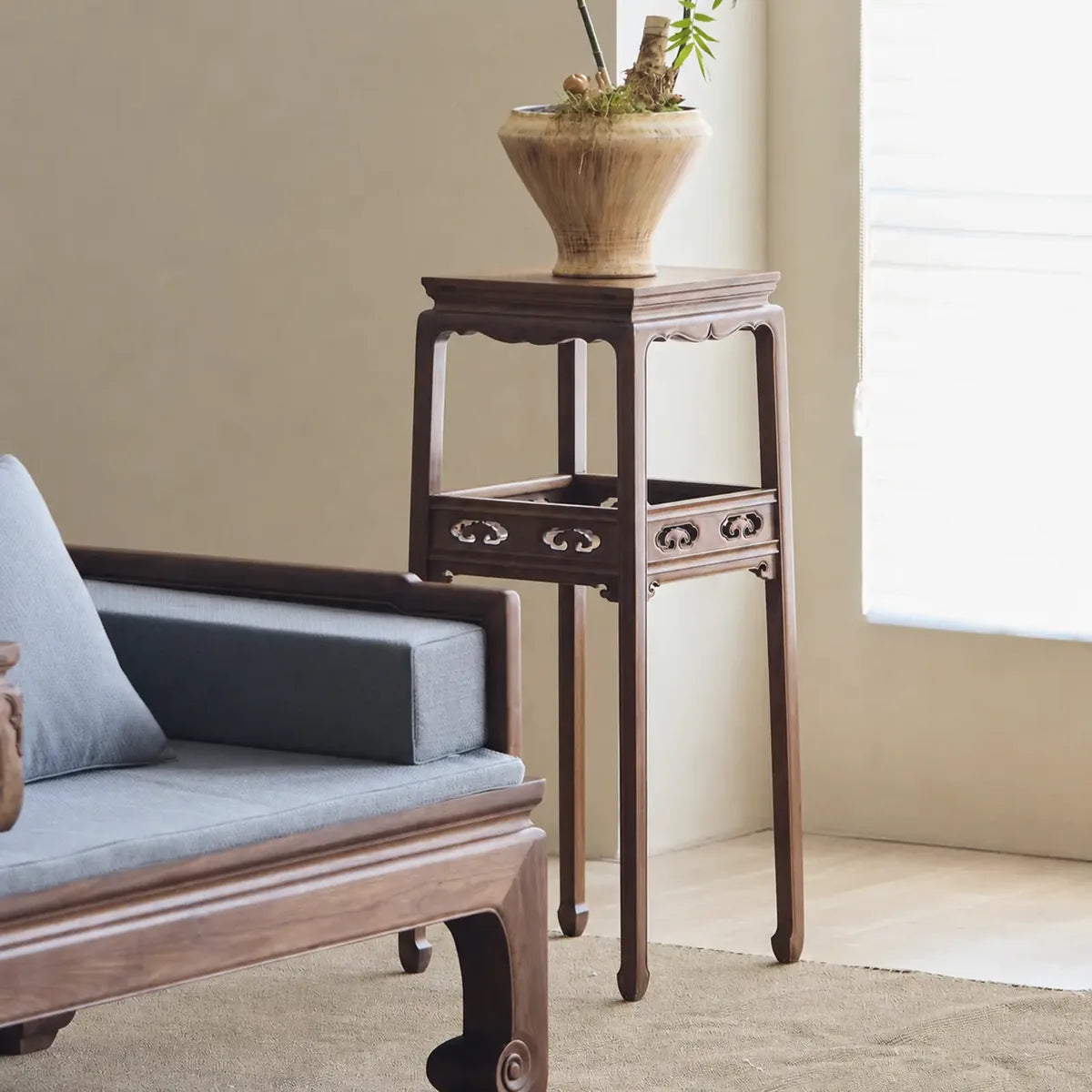 Tall black walnut flower stand beside a Luohan daybed