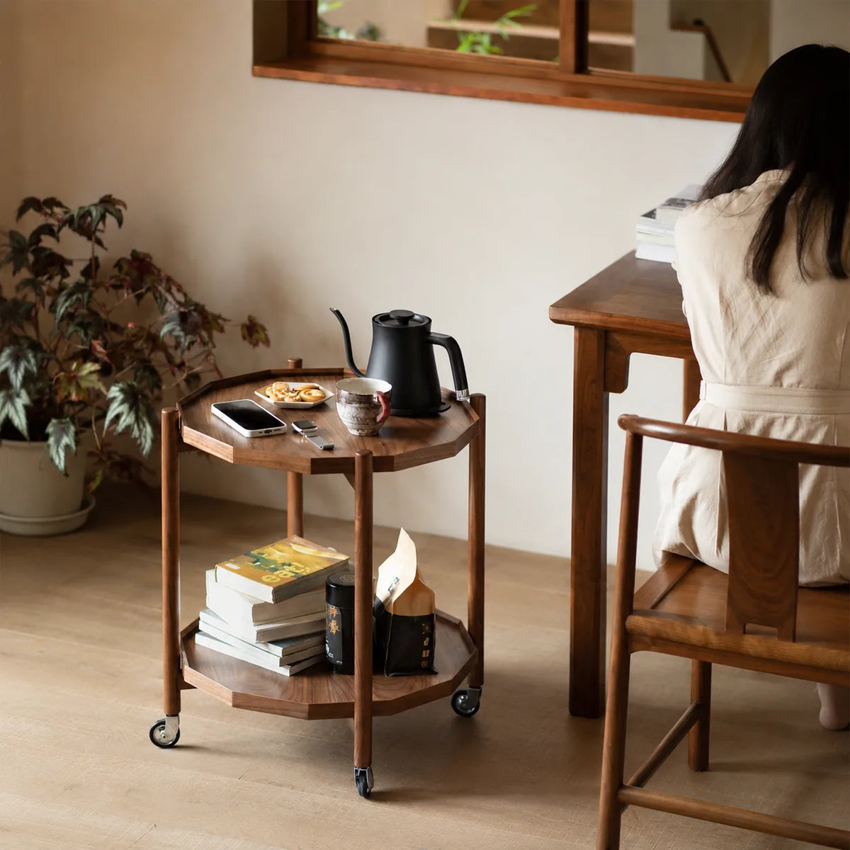 Two-tier walnut tea side table by a window