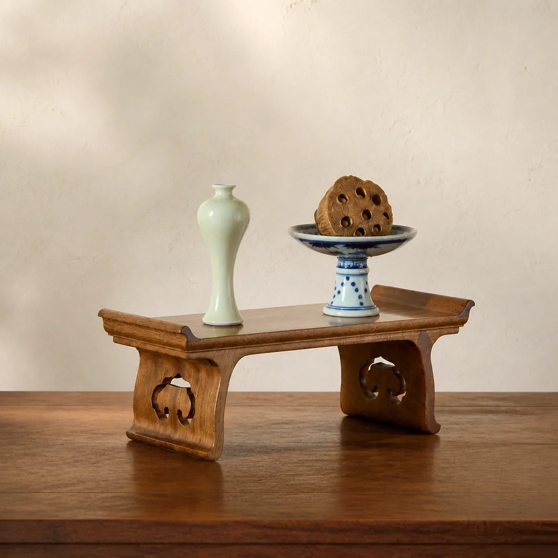 Handcrafted Golden Phoebe wood Ruyi display stand with celadon and blue-and-white objects
