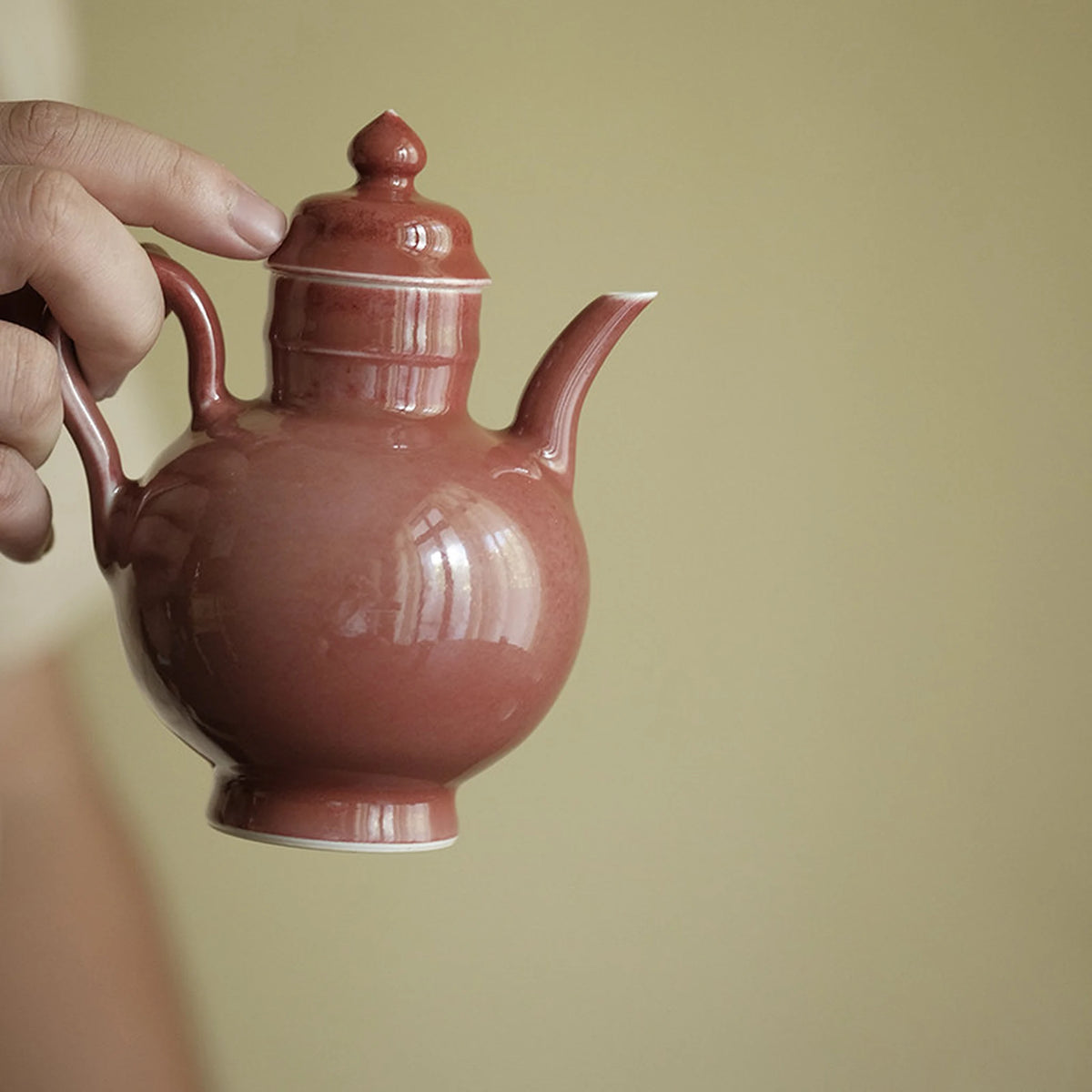 Close view of the rounded rose glaze teapot and curved spout