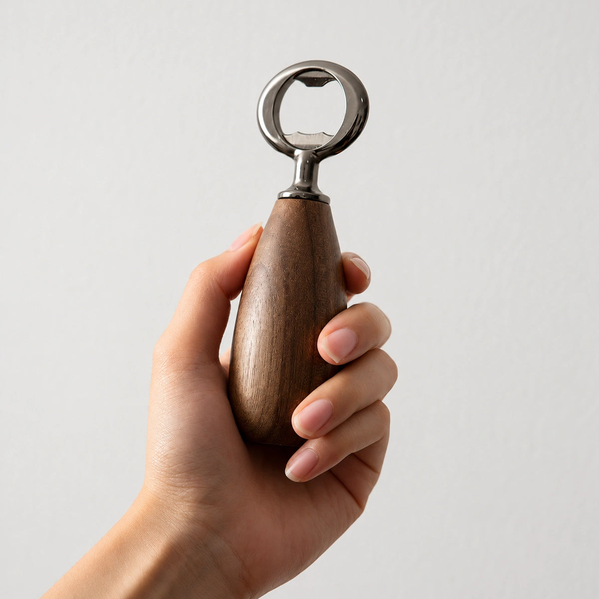 RUIZUO black walnut bottle opener held in hand, showing ergonomic wood handle and stainless-steel head